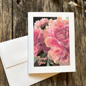 Thank You note card with a close up of pastel peony flowers, and white envelope, on a distressed wood background.